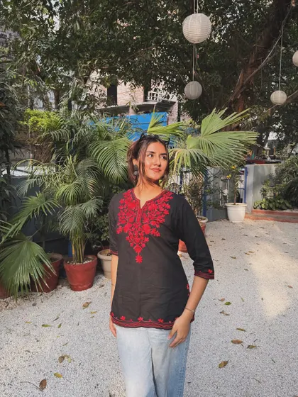 A sunny, happy picture in a black kurti with red embroidery, paired with jeans for a casual ethnic look.