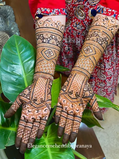 A stunning full-coverage engagement mehendi. The design is packed with geometric patterns, checks, and lotus motifs, creating a rich texture that looks beautiful from every angle.