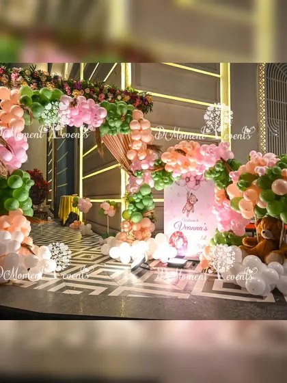 The entrance to a lovely teddy bear and floral themed party, with a beautiful arrangement of balloons and flowers creating a soft and welcoming vibe.