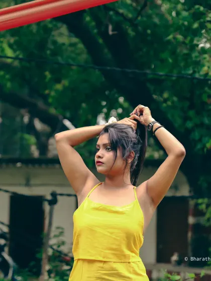Capturing a moment of interaction, like tying up hair, adds a dynamic and natural element to this outdoor portrait.