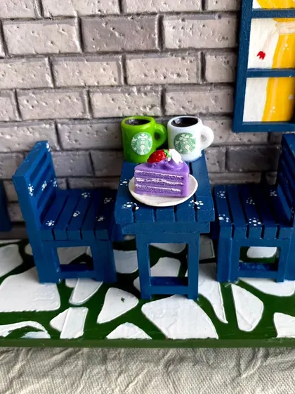 Here you can see the miniature Starbucks-style mugs and a slice of cake, adding a modern and personal touch to this custom nameplate's patio scene.