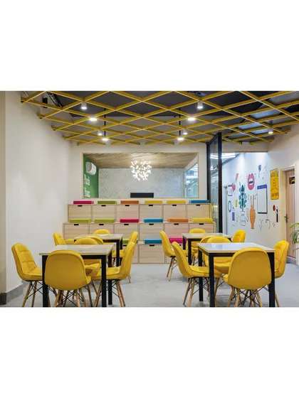 This event space at B-Hive 11 features amphitheater-style seating that doubles as storage. The design is both functional and playful, with colorful cushions and a large open area perfect for presentations and workshops.