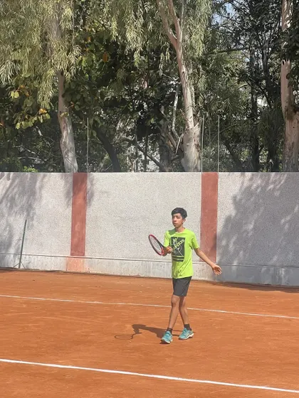 A player moving across the baseline during a match. Court coverage and movement are skills we constantly work on.