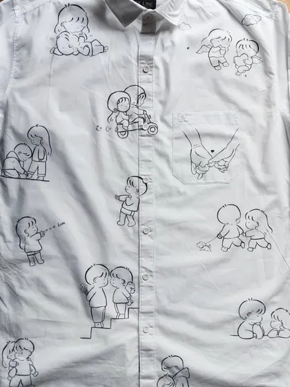 A full view of a custom doodle shirt I made. You can see various scenes like a scooter ride, sharing ice cream, and holding hands, all hand-painted to create a unique piece of wearable art.
