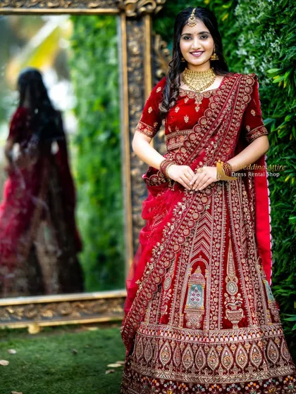 A smiling portrait of a model in the red velvet lehenga, showing how the outfit complements a joyful and celebratory mood.