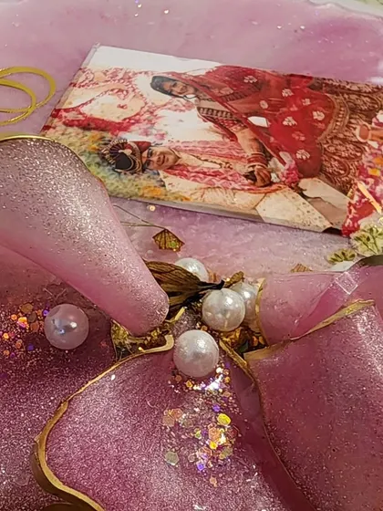 Another behind-the-scenes look at a wedding frame being made. This one has a beautiful pink theme with glittery petals and pearls.