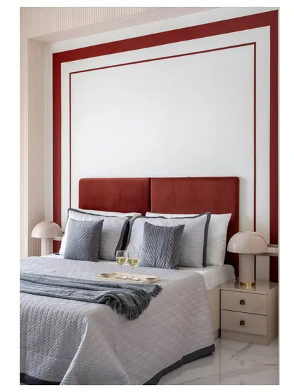 A cozy guest bedroom retreat. The brick-red headboard and blush-pink walls create a warm and inviting atmosphere, perfect for making visitors feel at home.