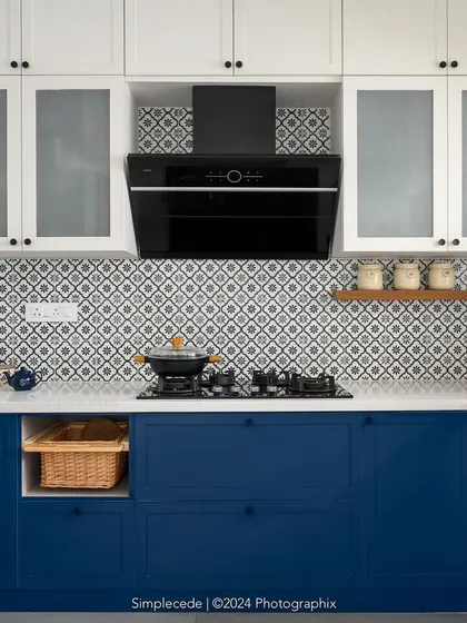 A close-up of the cooking area in the 'Cover me in Sunshine' kitchen, with its bold blue cabinets and classic white countertops.