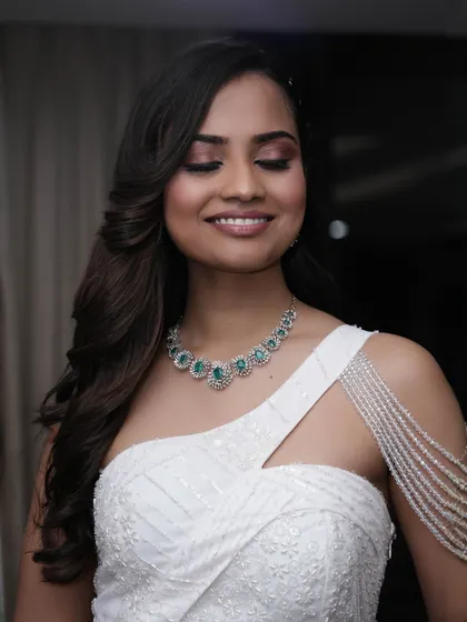 A smiling shot with eyes closed, highlighting the beautiful blend of brown eyeshadow. It's a perfect example of a soft and subtle smokey eye.