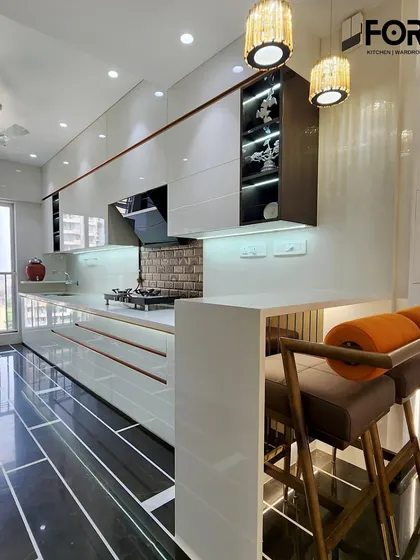 A closer look at the breakfast bar in this open-plan kitchen. The clean white countertop and warm lighting make it an inviting spot for a quick meal or a morning cup of coffee.