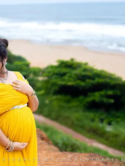 A serene portrait of the mom-to-be on the cliffs overlooking the ocean, her hand gently resting on her bump.