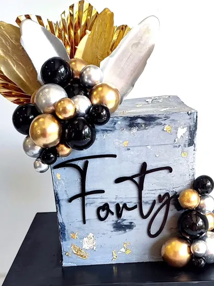A close-up of the abstract 40th birthday cake, showing the details of the textured ganache and metallic accents.