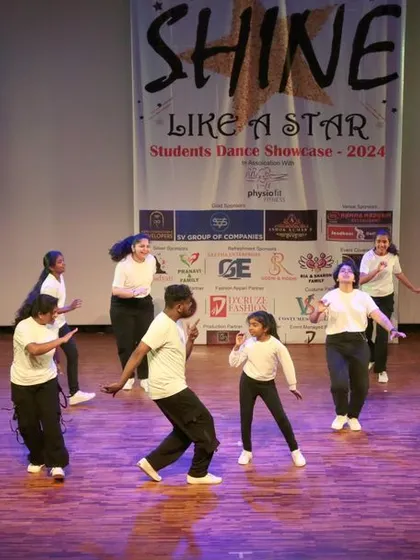 The entire group moving together in a dynamic moment from their stage performance. We focus on teamwork and coordination in our group choreography.