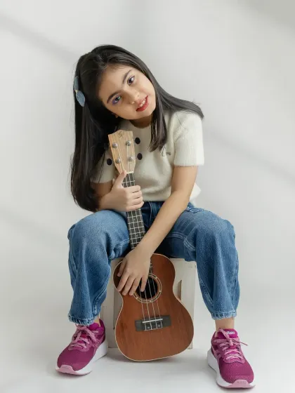 A calm and gentle portrait with her ukulele. It's great to include props that showcase a child's hobbies and interests.
