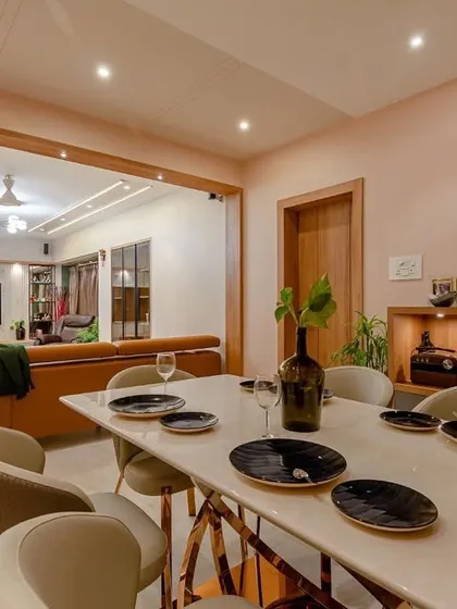 An expansive view from the dining area to the living room, showcasing a large, open-plan space designed for a modern family. The consistent color palette and lighting create a unified and harmonious feel.