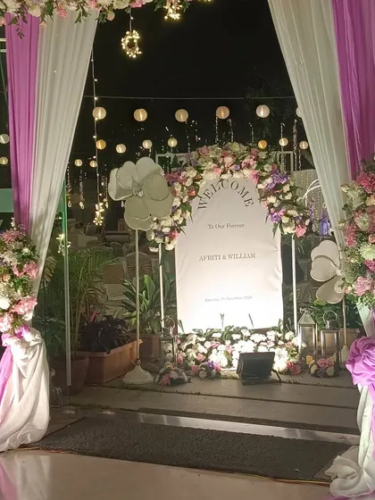 Another view of the stylish reception entrance, showing the interplay of lights, drapes, and flowers.