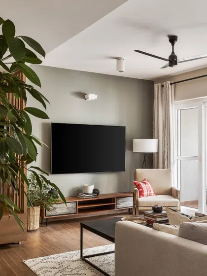 The TV and media area in the 'Ikigai Living' apartment. A simple, low-profile console and a large indoor plant keep the space feeling open and connected to our biophilic design philosophy.