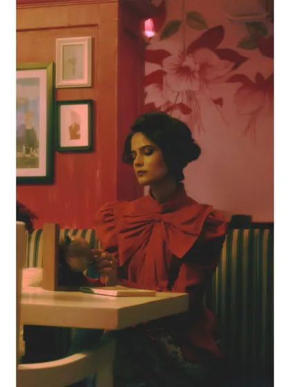 A scene from "Gallery of expectations," Chapter 4 of the series. The subject sits alone in a vibrant, romanticized setting, embodying the act of building a future in one's mind.