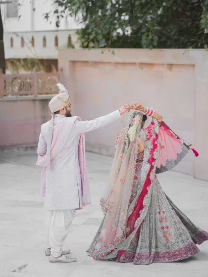 A beautiful shot of the groom twirling his bride, showing the flow and grace of her intricate wedding lehenga. This is a classic, romantic pose that I love to capture.