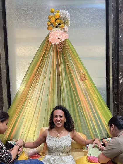 A happy guest getting her Mehendi done in a seating area I designed. I ensure there are multiple comfortable spots for guests to participate in the traditions.