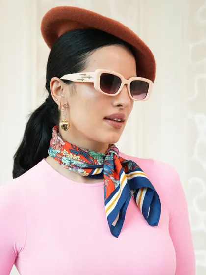 Another angle of the second look from the Crocs campaign. The combination of the bright pink top, printed scarf, and retro sunglasses creates a vibrant and eye-catching commercial fashion look.
