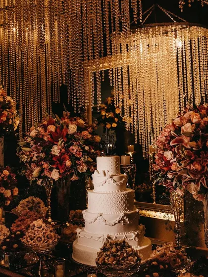 A magnificent multi-tiered wedding cake, surrounded by an extravagant display of flowers and desserts. This dessert station becomes a stunning focal point, showcasing our belief that every course, especially the finale, should be a work of art.