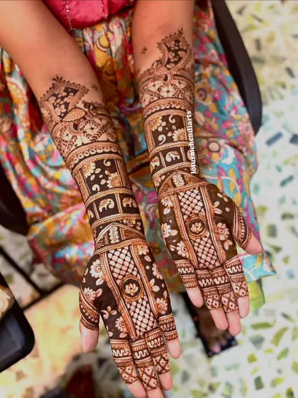 An intricate bridal design showcasing a mix of floral bands, checkered patterns, and traditional motifs like elephants and paisleys, covering the hands and arms beautifully.