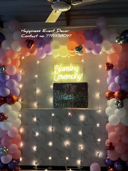 Another view of the naming ceremony balloon arch, showing how the fairy lights behind the curtain add a sparkling effect. This setup is perfect for home celebrations.