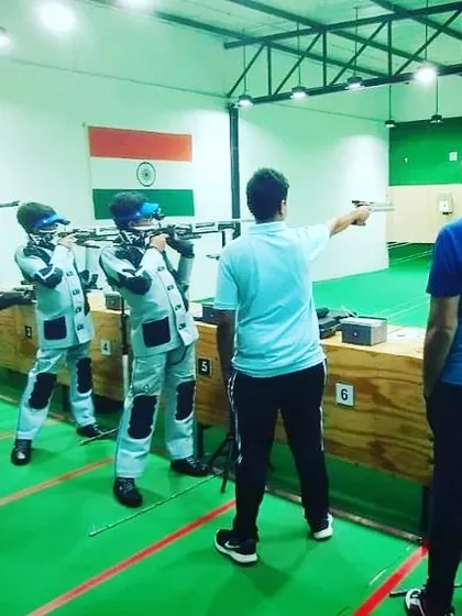 A coach provides guidance during a group training session. We offer hands-on instruction for both air rifle and air pistol disciplines, ensuring every student improves their technique.