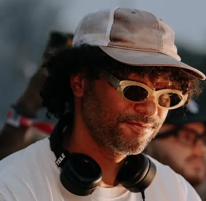 A close-up, candid shot of &ME, capturing his cool, focused demeanor as he curates the soundtrack for the evening.