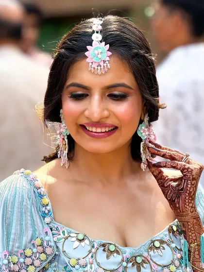 A candid shot showing the intricate henna design and the beautiful floral jewelry.