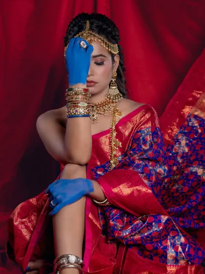 A dramatic pose that highlights the contrast between the traditional saree and the modern, artistic elements.