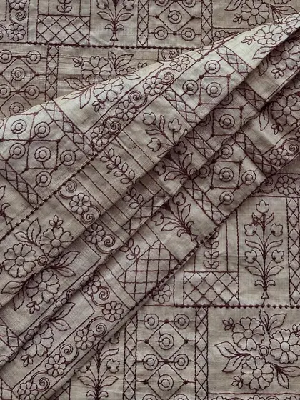 The intricate panel embroidery on this Tussar silk fabric creates a stunning visual effect. Its natural texture makes it perfect for structured yet elegant outfits.