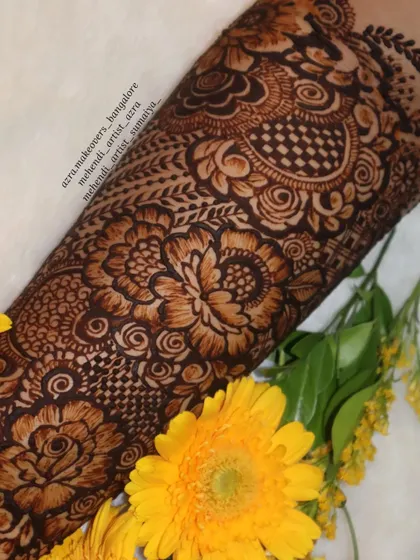 A beautiful close-up of a floral bridal mehendi, artfully arranged with yellow flowers.