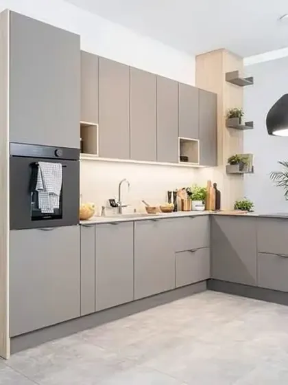 An L-shaped kitchen in a calming grey and light wood palette. We incorporated open shelving and a small counter extension to create a light, airy, and highly functional cooking space.