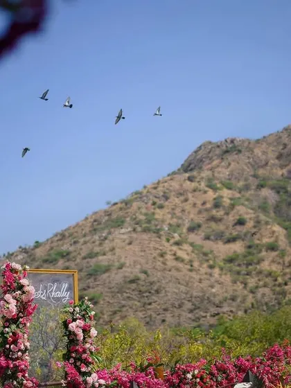 The beauty of decor that sits just right in its setting, with the floral backdrop framed by the natural landscape and birds flying overhead.