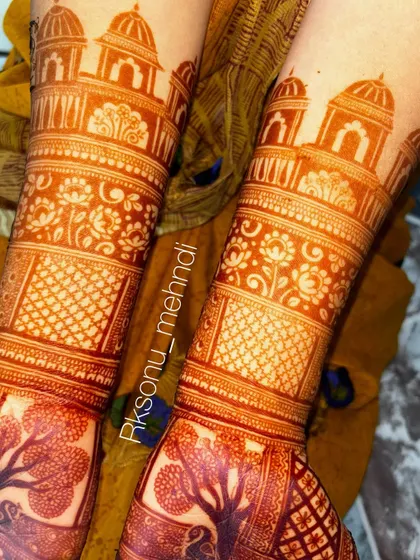 The beautiful, deep orange stain of a full bridal design. This photo shows the mehndi after the paste has been removed, highlighting the intricate details of the tree of life, peacock, and architectural motifs.