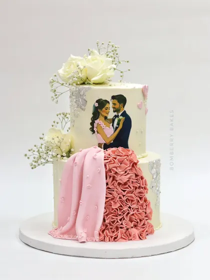 A personalized two-tier wedding cake featuring a custom illustration of the couple, with a flowing, ruffled fondant dress.
