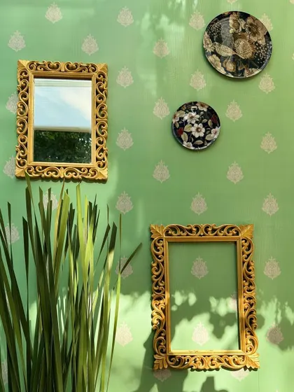 The play of sunlight and shadow on the wall decor, highlighting the intricate details of the frames and plates.