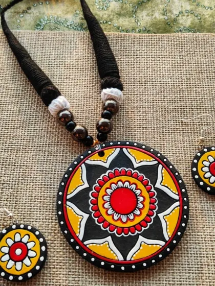 A yellow, black, and red version of the mandala pendant necklace.