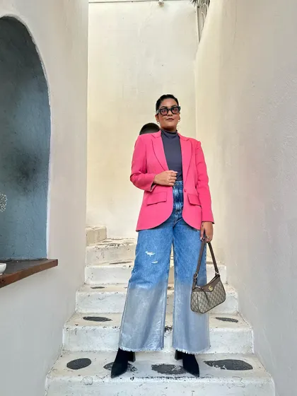 A pop of color makes everything better. Here, a bright pink blazer is layered over a grey turtleneck and two-tone wide-leg jeans.