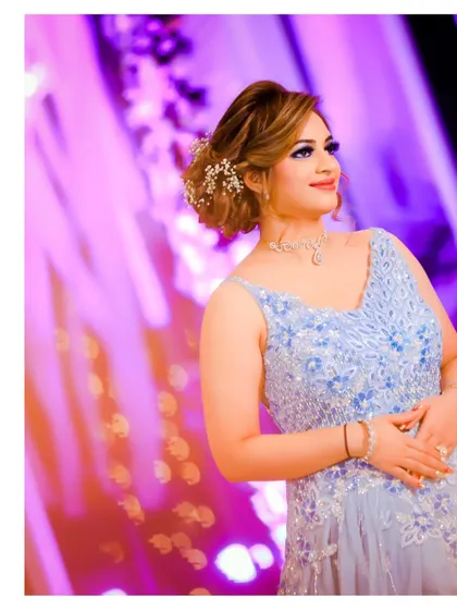 A beautiful solo portrait of the bride, bathed in the soft, colorful lights of her engagement party. Her elegant updo with floral accessories completes the look.