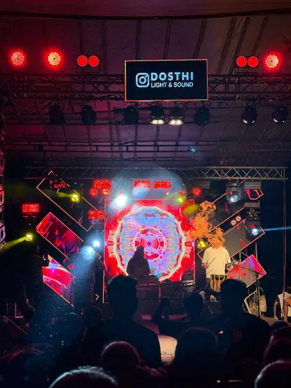 The stage is bathed in red light as my Chenda artists perform alongside me, with my custom visuals pulsing on the LED screen.