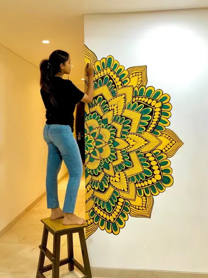 A half mandala painted directly onto the wall, creating a unique and beautiful feature in this home's hallway. The yellow and green colors bring so much life to the space.