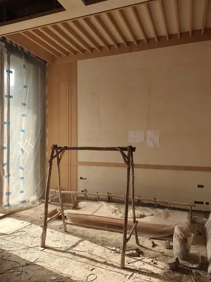 An interior view of the DLF Phase 1 residence, showing the installation of wooden ceiling rafters and wall paneling, key elements of its minimalistic design.