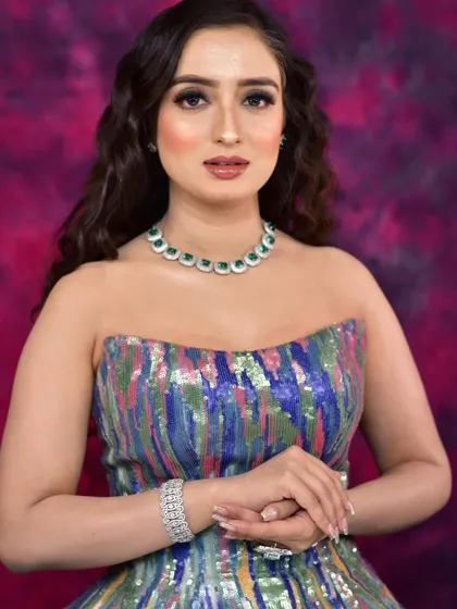 A model looking chic and modern in a strapless sequin gown, paired with our elegant emerald and diamond necklace and a matching bracelet.