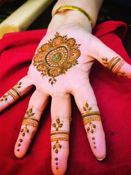 A simple and beautiful mandala design, perfect for a quick festive look. The central point is filled with henna, creating a dark, bold center.