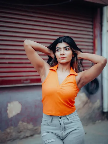 A full-length shot of a model in a casual outfit. The urban background and her relaxed pose are perfect for a street style lookbook.