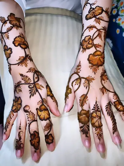 A delicate and whimsical vine pattern, with flowers and leaves that seem to dance across the hands and arms.