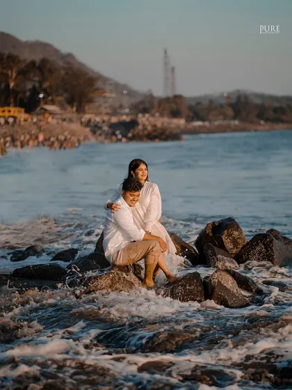 Komal and Ajit sit together on a rock as the tide comes in around them. This shot beautifully integrates the couple into the natural landscape of the beach.